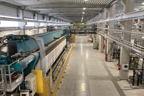 Una composición técnica que muestra a la izquierda un filtro prensa de viga superior Diemme® Filtration de la serie GHT operando en una mina de gran escala, y a la derecha un filtro de viga lateral de la serie ME en una planta química de alta eficiencia, destacando las diferencias estructurales y de acceso.